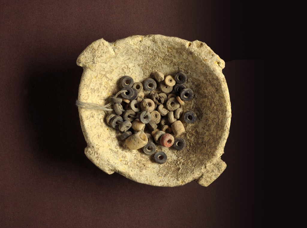 קערת אבן ובה חרוזים עתיקים שנמצאו בחפירות בעין ציפורי - צילום: קלרה עמית, רשות העתיקות