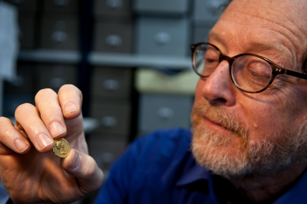 ד"ר דונלד צבי אריאל, ראש ענף מטבעות ברשות העתיקות, בוחן את המטבע הנדיר. צילום: שי הלוי, רשות העתיקות