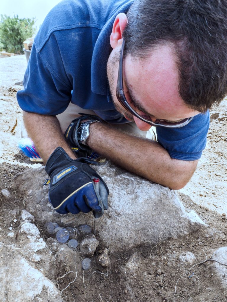 ארכיאולוג רשות העתיקות, שחר קריספין, בעת גילוי מטמון מטבעות הכסף שנמצא בבית האחוזה. צילום: אסף פרץ