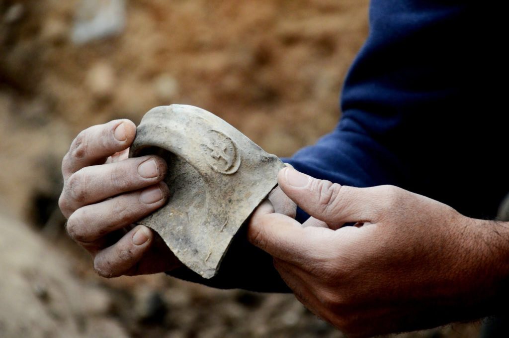 טביעת חותם על ידית קנקן "למלך חברן" בעת חשיפתה בשטח– צילום: יולי שוורץ