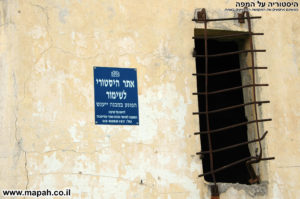 שלט כחול המועצה לשימור על קיר משטרת באטאני - צילום: אפי אליאן