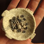 קערת האבן ושרשרת החרוזים העתיקה שנחשפה בעין ציפורי - צילום: קלרה עמית, רשות העתיקות