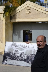 רון שני מציג תמונה ישנה של מפעילי פרדס מינקוב - צילום רפרודוקציה : אפי אליאן