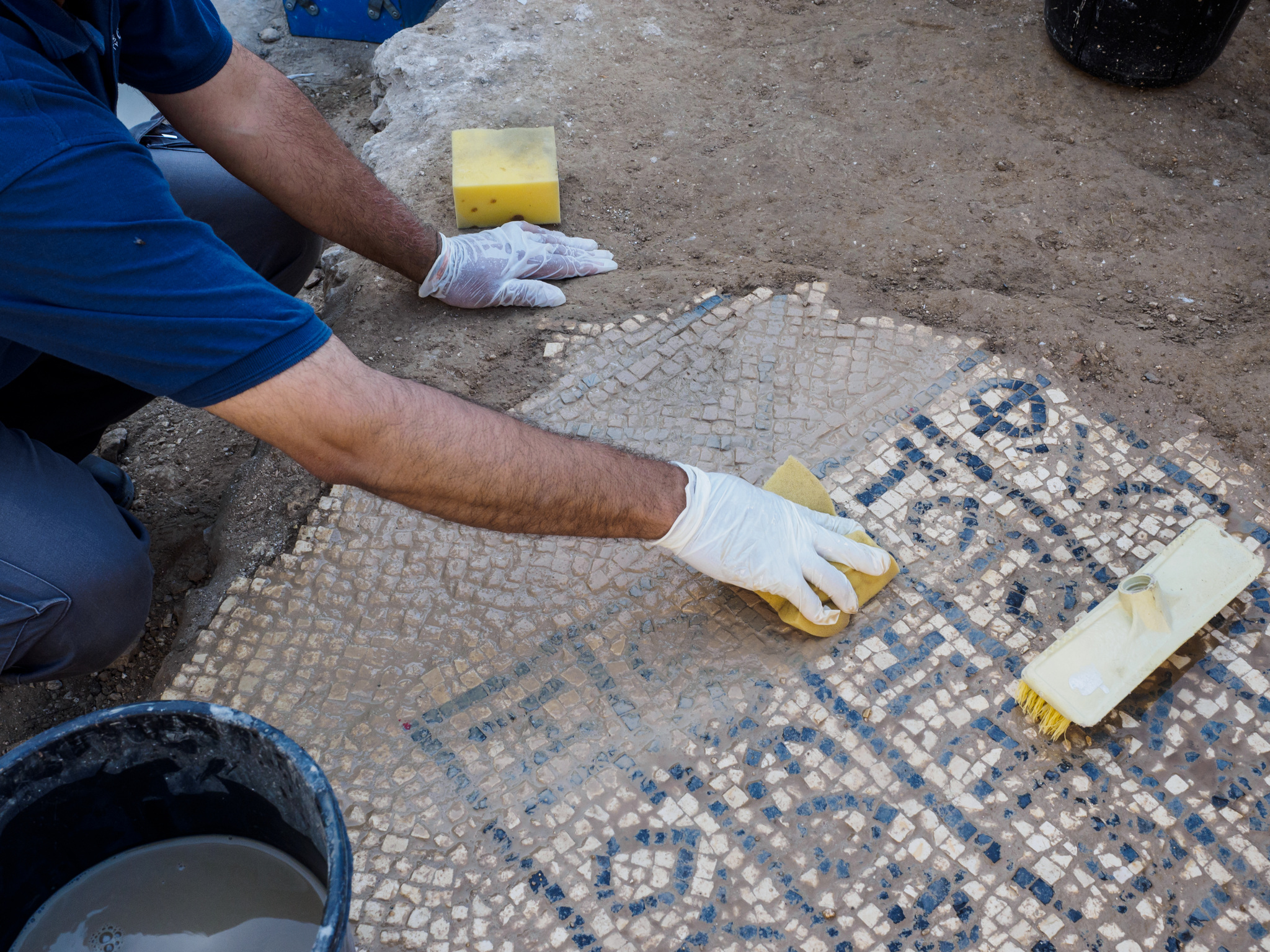 חישוף הכתובת בפסיפס שנמצא בשער שכם - צילום: אסף פרץ