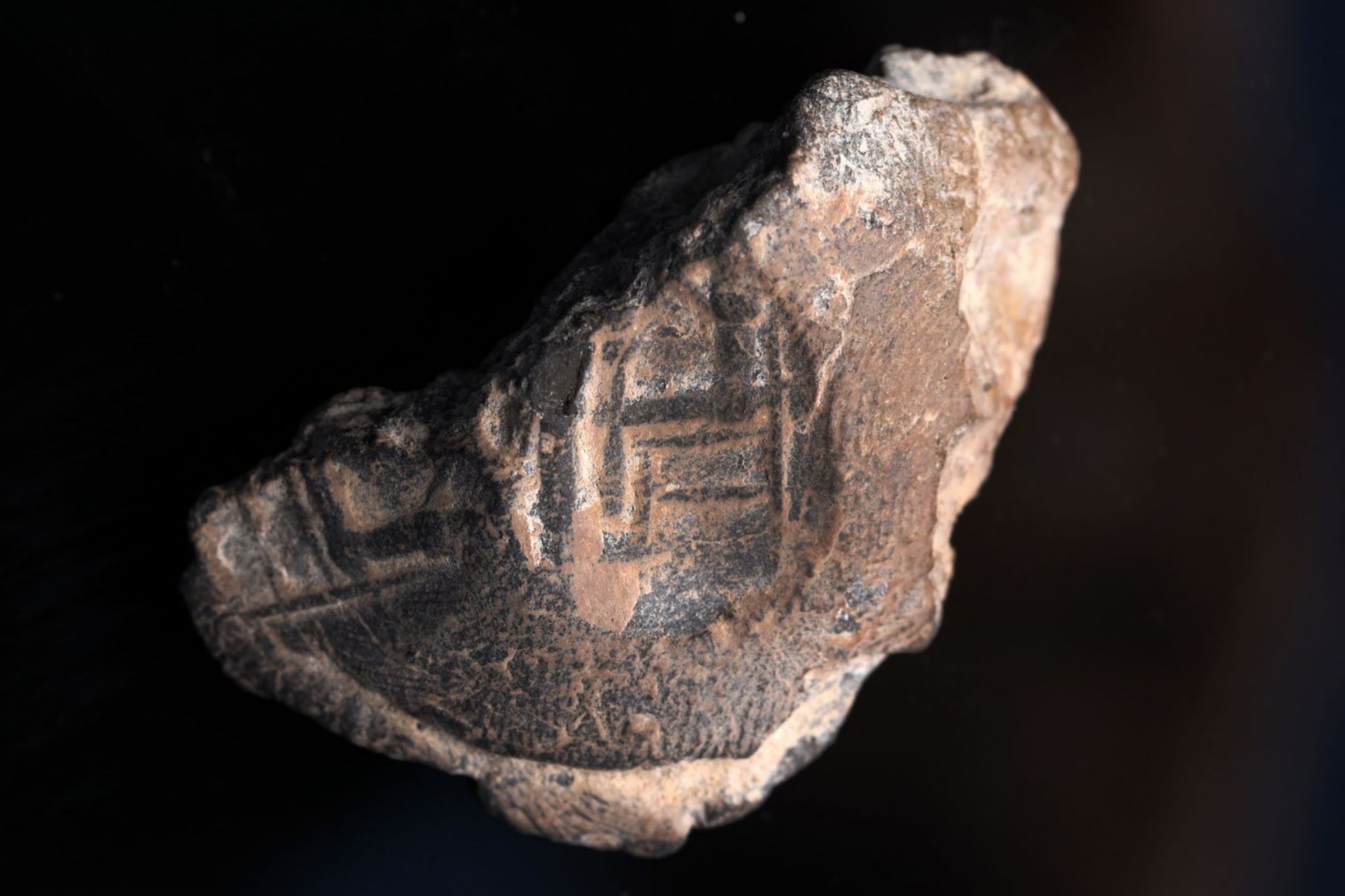 טביעת חותם שעליה הטביעה מופיעה דמות של אדם היושב על כיסא גדול (ככל הנראה מלך). צילום: אליהו ינאי
