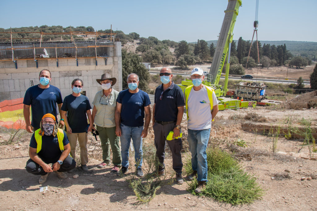 . אנשי רשות העתיקות וקיבוץ חנתון על רקע המקווה המונף לפני העברתו לקיבוץ. צילום יולי שוורץ 