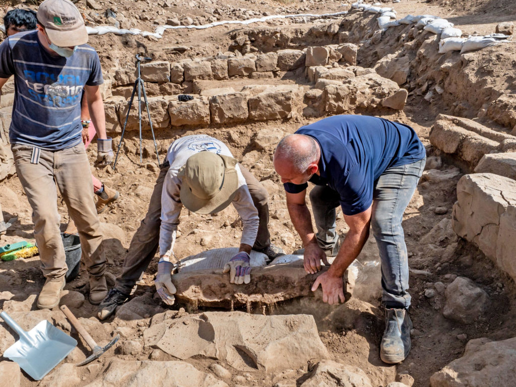פועלים מרימים את אבן הגבול שהתגלת בנפח. צילום אסף פרץ רשות העתיקות
