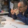דר' רוברט קול בוחן את אחד המטבעות שנמצאו בפכית. צילום שי הלוי רשות