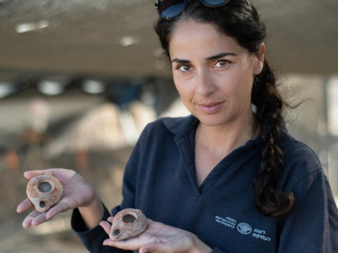 מנהלת החפירה, מורן בלילה, מחזיקה נרות שמן בני כ-1600 שנה. צילום: יולי שוורץ