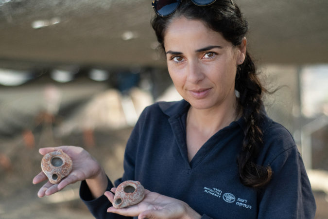 מנהלת החפירה, מורן בלילה, מחזיקה נרות שמן בני כ-1600 שנה. צילום: יולי שוורץ