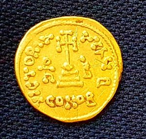 מטבע הזהב שנחשף בחפירה ועליו חריטה לסימון בעלות. צילום אמיר גורזלזני