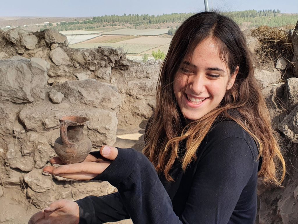 תמר כהן, תלמידת מגמת לימודי ארץ ישראל וארכיאולוגיה באולפנת דימונה, מחזיקה פכית הלניסטית שגילתה בחפירה. צילום - סער גנור