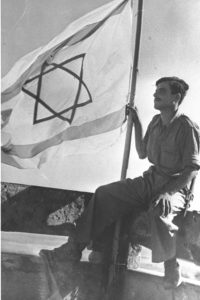 מלחמת העצמאות. בצילום, חייל ישראלי מניף את דגל ישראל בתחנת המשטרה עירק סוידן לאחר כניעתה.- צילום: ארכיון לע"מ