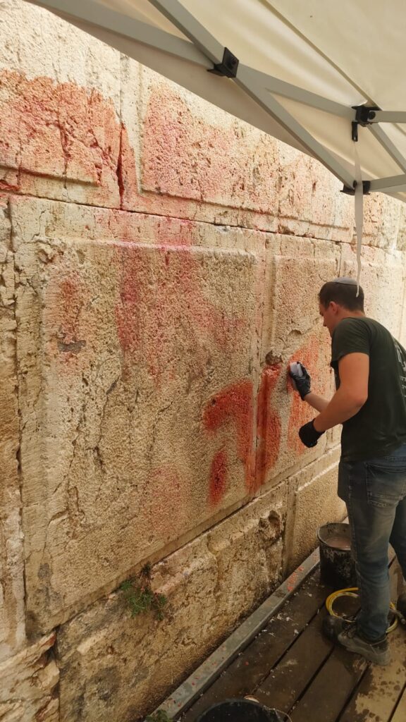 משמרי רשות העתיקות בעת מחיקת הכתובת הבוקר בכותל. צילום - מינהל שימור, רשות העתיקות