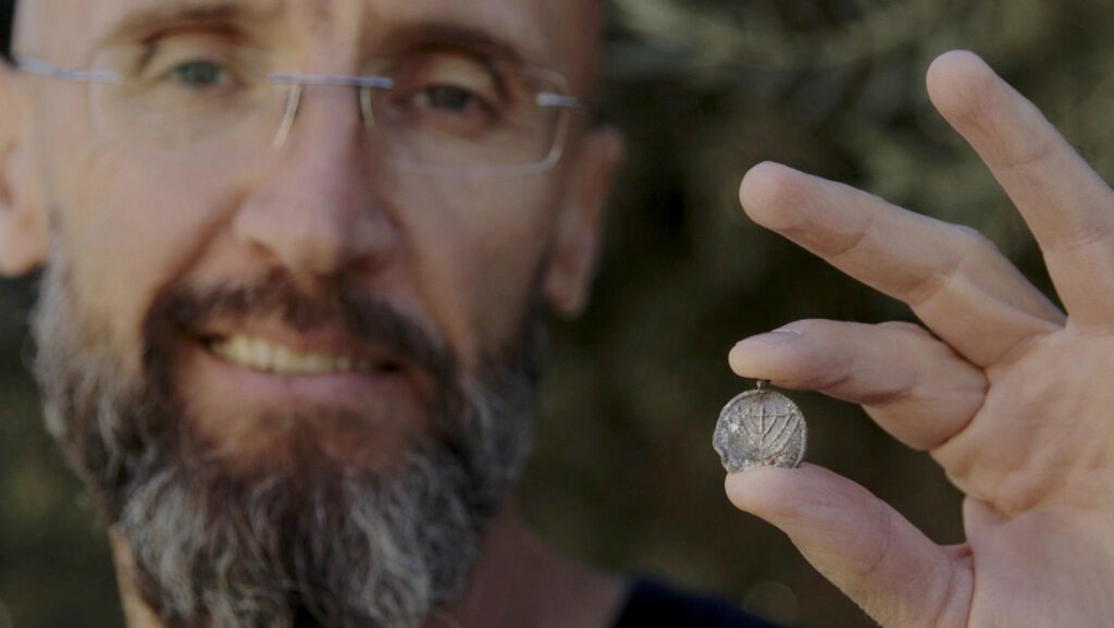 ד"ר פיליפ ווקוסבוביץ מרשות העתיקות עם התליון. צילום אמיל אלג'ם 