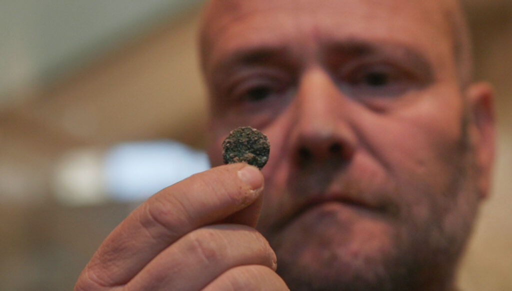 מטבע שאך נתגלה בחפירה. צילום אמיל אלג'ם