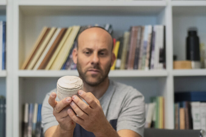 ד"ר איתן קליין מחזיק גרעין של כלי אבן בן כ-2,000 שנה. צילום: יולי שוורץ