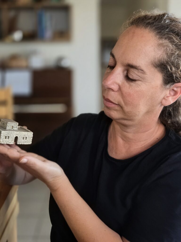 אוצרת התערוכה דר עינת עמבר ערמון עם חלק מדגם בית הכנסת בעת בנייתו.- צילום רשות העתיקות